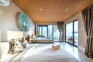 a bedroom with a large bed and a large window at Cozy Beachfront Samroiyod in Baanphakrimlay  +30 photos
