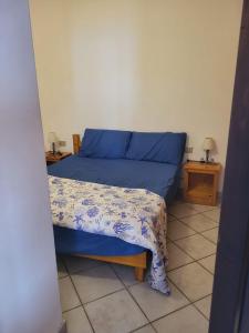 a bedroom with a bed with a blue comforter at Villa Sunny Side - Panoramic View in Costa Paradiso +19 photos