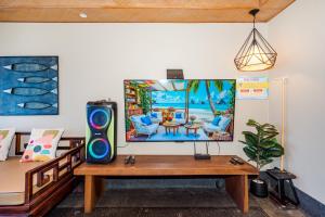 a room with a table with a television on it at Cozy Beachfront Samroiyod in Baanphakrimlay 