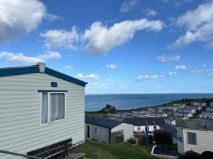 a view of a row of houses and the ocean at Beer Head Caravan Park B68 in Seaton