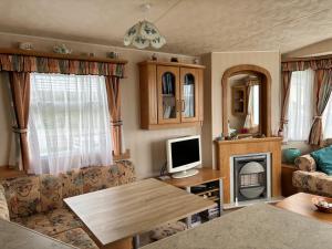 a living room with a table and a television at Beer Head Caravan Park B68 in Seaton