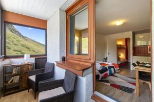 a room with a desk and chairs and a bedroom at La Mongie Parking Petfriendly in Bagnères-de-Bigorre