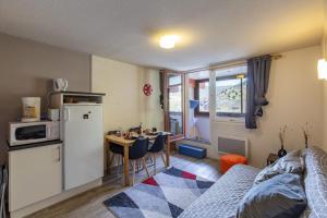 a kitchen with a refrigerator and a table in a room at La Mongie Parking Petfriendly in Bagnères-de-Bigorre +7 photos