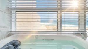 a bath tub in a bathroom with a window at Goseong Moneblue Pension in Goseong +10 photos