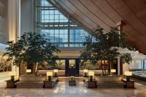 a lobby with two trees in a building at Gran Meliá Jakarta in Jakarta