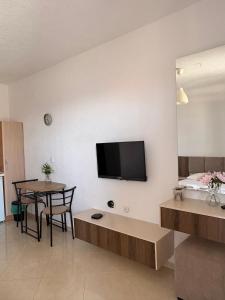 a living room with a table and a tv on a wall at Vila Vavilon in Star Dojran