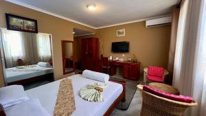 a room with a bed and a table and chairs at Lush Garden Hotel in Arusha +29 photos