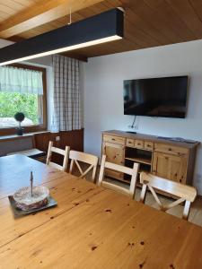 a dining room with a wooden table with chairs and a television at Ferienhaus Riedberg in Ried im Zillertal