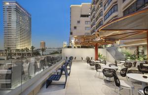 an outdoor patio with tables and chairs and umbrellas at Pyramisa Suites Hotel Cairo in Cairo