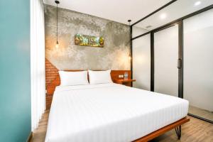 a bedroom with a white bed and a brick wall at Noesa Heritage in Surabaya