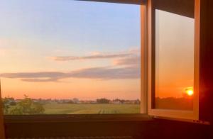 a window with a view of a sunset at Latte e Menta House in Casale