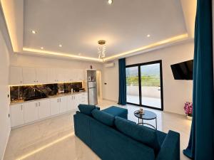 a living room with a blue couch and a kitchen at Central Luxury Rooms in Alikanas