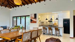 a kitchen and dining room with a wooden table and chairs at Eden Collection Thalpe in Talpe
