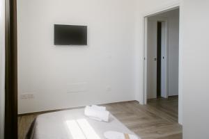 a white room with a bed and a television at Erigia House - Appartamenti Eleganti - Molfetta in Molfetta +32 photos