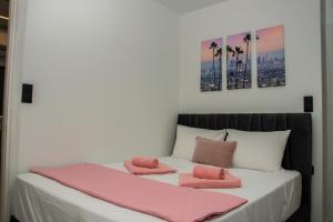 a bed with pink towels on top of it at COMFY Apartments in Alexandroupoli