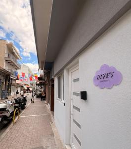 a white building with a purple com entity sign on it at COMFY Apartments in Alexandroupoli