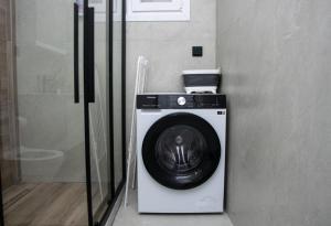 a washing machine in a corner of a room at COMFY Apartments in Alexandroupoli