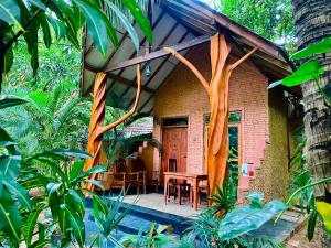 a house with a wooden door and a table at Ama Eco Lodge in Sigiriya
