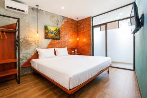 a bedroom with a bed and a brick wall at Noesa Heritage in Surabaya +11 photos