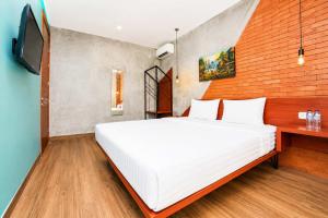 a bedroom with a white bed and a television at Noesa Heritage in Surabaya
