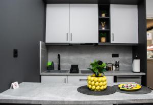 a kitchen with white cabinets and a table with a plate of food at COMFY Apartments in Alexandroupoli
