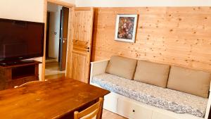 a living room with a couch and a television at villa Ada apartment in Cercivento