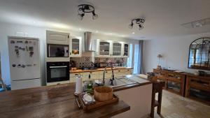 a kitchen with white appliances and a wooden counter top at La Grange de Cablanc in Monestier