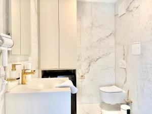a white bathroom with a sink and a toilet at Rooftop Deluxe Apartment LEGRAND in Vienna +46 photos