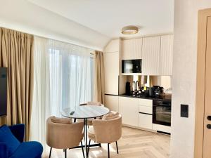 a kitchen with a table and chairs in a room at Rooftop Deluxe Apartment LEGRAND in Vienna