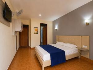 a bedroom with a large bed with a blue blanket at Pensão Asa Branca in Assomada +28 photos