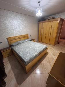 a bedroom with a bed and wooden cabinets at Apartment Selouane in Selouane