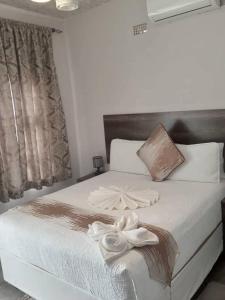 a bedroom with a bed with white towels on it at Kgajane Guest House in Molepolole
