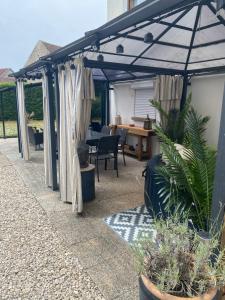 a patio with an umbrella and some plants and a table at Chez Nanou in Marmagne +8 photos