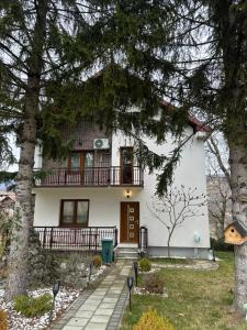 a white house with a balcony and trees at Te Pishat in Brezovica