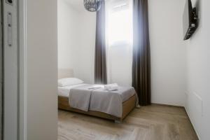 a bedroom with a bed and a large window at Erigia House - Appartamenti Eleganti - Molfetta in Molfetta
