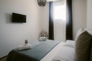 a bedroom with a bed with a tv on the wall at Erigia House - Appartamenti Eleganti - Molfetta in Molfetta