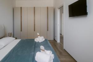 a bedroom with a bed and a flat screen tv at Erigia House - Appartamenti Eleganti - Molfetta in Molfetta