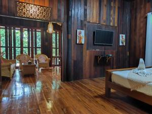a bedroom with a bed and a tv on a wall at Nan De Panna Homestay in Nan