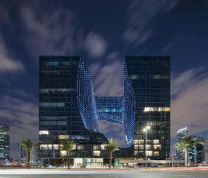 two tall buildings are lit up at night at ME by Meliá Dubai Residences in Dubai
