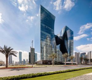 a tall glass building with a bird sculpture in front of a city at ME by Meliá Dubai Residences in Dubai