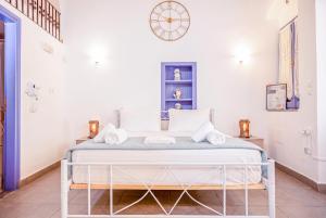a bed in a room with a clock on the wall at Kali Strata 2 - Downtown in Symi