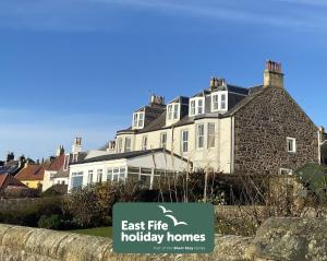 a large house with a sign that says east fire holiday homes at Craigiebank - Lower Largo in Lower Largo