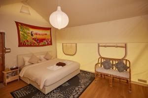 a bedroom with a bed and a chair at The Woods Beachfront Tent Yao Noi in Ko Yao Noi