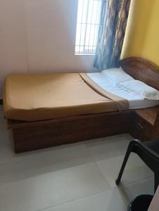 a bed with a wooden frame in a room at Sri Sapthagiri Comforts in Mysore