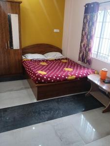 a small bed in a room with a window at Sri Sapthagiri Comforts in Mysore
