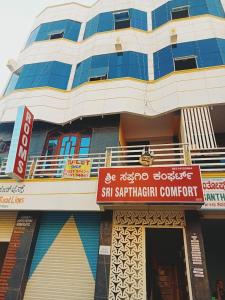 a building with a sign in front of it at Sri Sapthagiri Comforts in Mysore