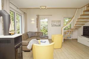 a living room with a couch and yellow chairs at Ferienhaus am Dünenstrand in Baabe