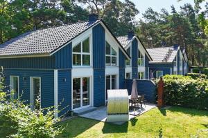 a blue and white house with a patio at Ferienhaus am Dünenstrand in Baabe