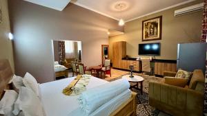 a hotel room with a bed and a living room at Lush Garden Hotel in Arusha