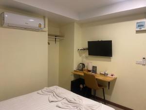 a hotel room with a desk and a bed at Shwe Ooe Lay Guest House 2 in Pratunam